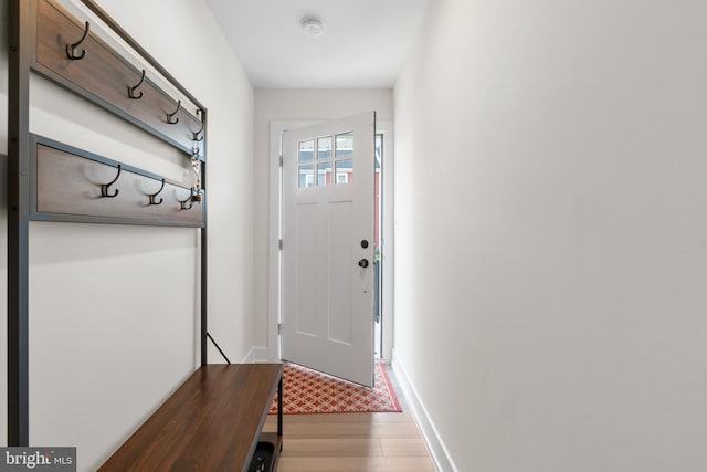 doorway featuring light wood finished floors and baseboards