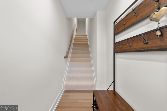 stairs with wood finished floors and baseboards