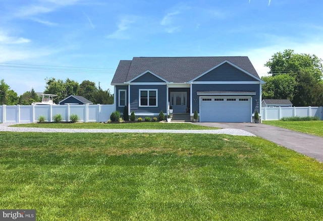 view of front of house with aphalt driveway, fence, and a front yard