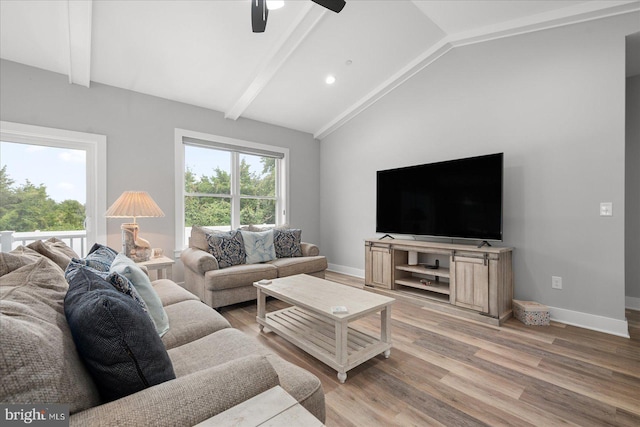 living room featuring light hardwood / wood-style floors, ceiling fan, and lofted ceiling with beams