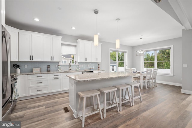 kitchen with light hardwood / wood-style flooring, a center island, and white cabinetry