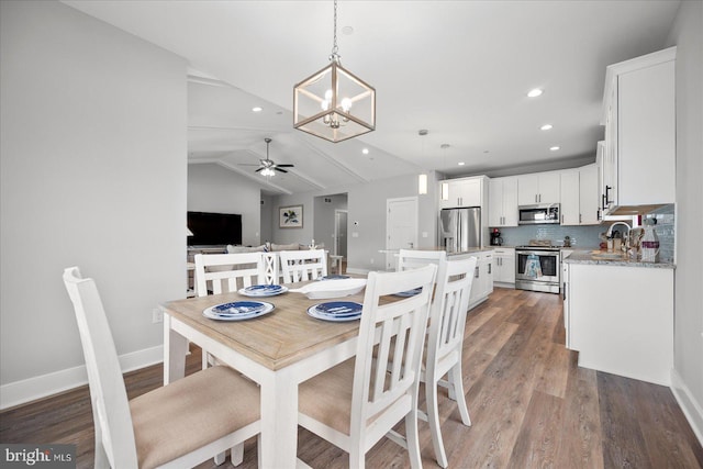 dining room with ceiling fan with notable chandelier, recessed lighting, light wood-style floors, baseboards, and vaulted ceiling