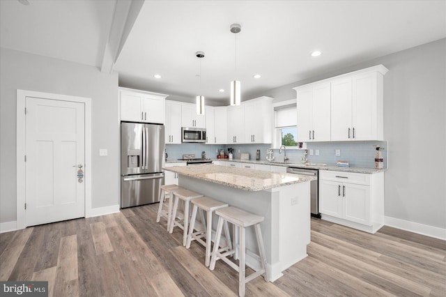 kitchen with light hardwood / wood-style flooring, stainless steel appliances, and white cabinets