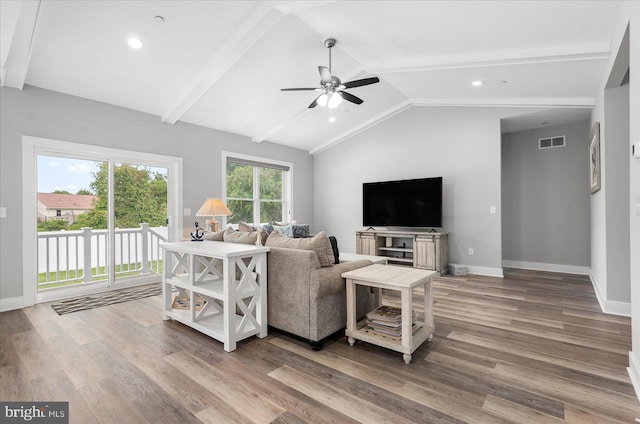 living area with visible vents, vaulted ceiling with beams, ceiling fan, baseboards, and wood finished floors