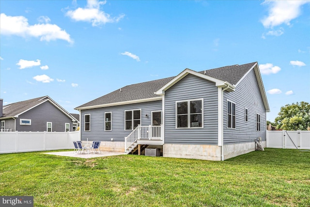 rear view of house with a gate, a patio area, a yard, and a fenced backyard