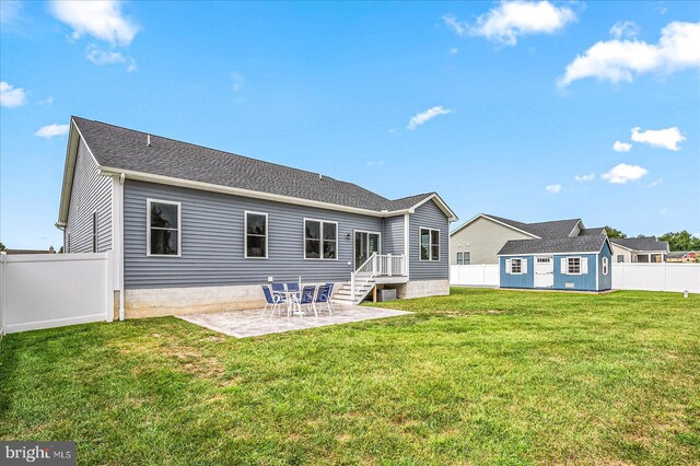 back of property with a patio area and a yard