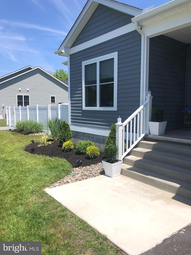 property entrance featuring a lawn and a patio area