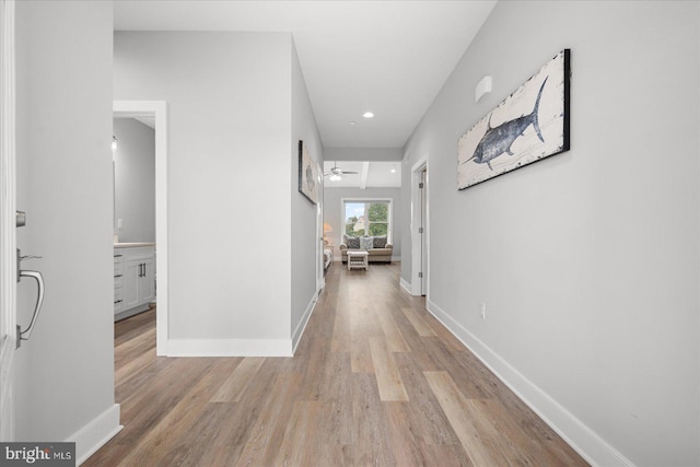 hallway with recessed lighting, baseboards, and light wood finished floors