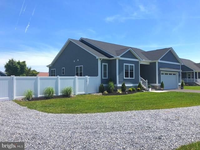 view of front of property with a front yard, an attached garage, fence, and driveway