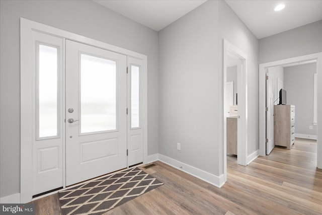 foyer entrance featuring baseboards and light wood-type flooring