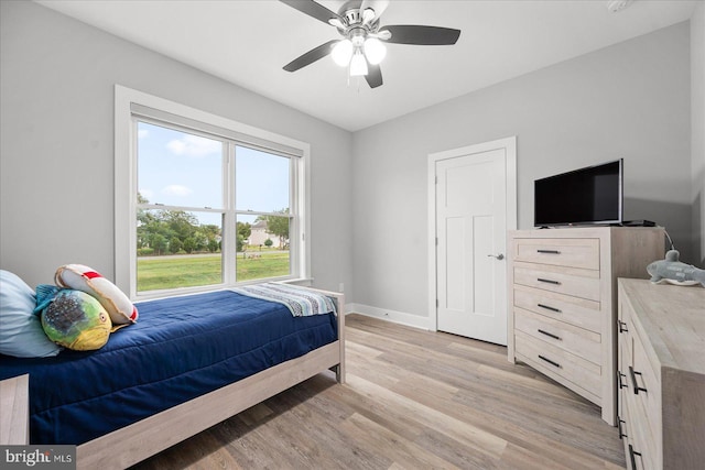 bedroom with light wood-type flooring, baseboards, and ceiling fan