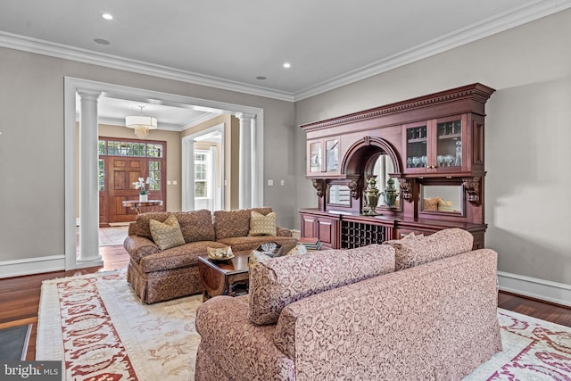 living room featuring ornate columns, crown molding, and light hardwood / wood-style flooring