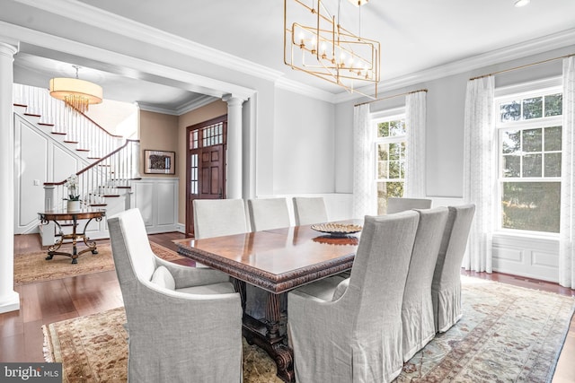 dining area with ornamental molding, decorative columns, and dark wood-type flooring