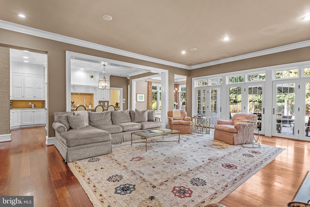 living room featuring ornamental molding, hardwood / wood-style flooring, and a chandelier