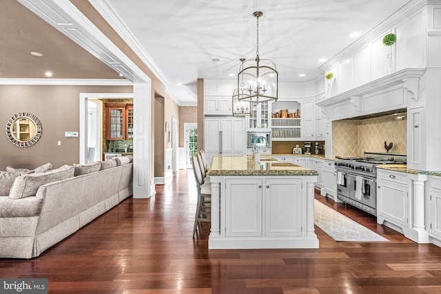 kitchen with a center island with sink, white cabinetry, range with two ovens, and dark hardwood / wood-style floors