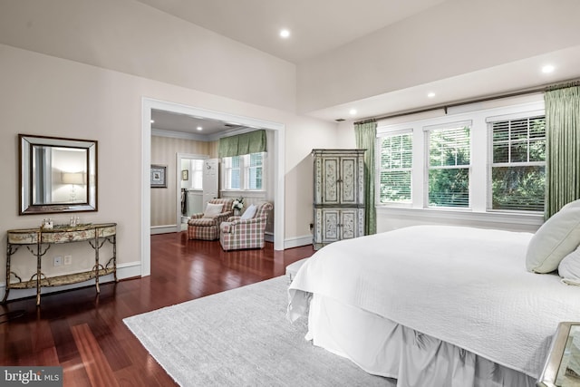 bedroom with dark hardwood / wood-style floors, ornamental molding, and multiple windows