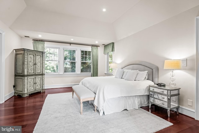 bedroom with dark wood-type flooring and lofted ceiling