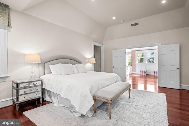 bedroom with high vaulted ceiling and dark wood-type flooring