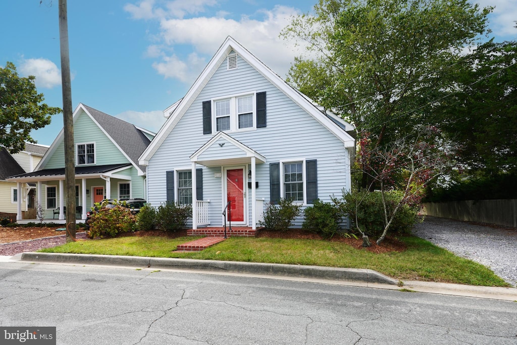bungalow-style home with a front yard and fence