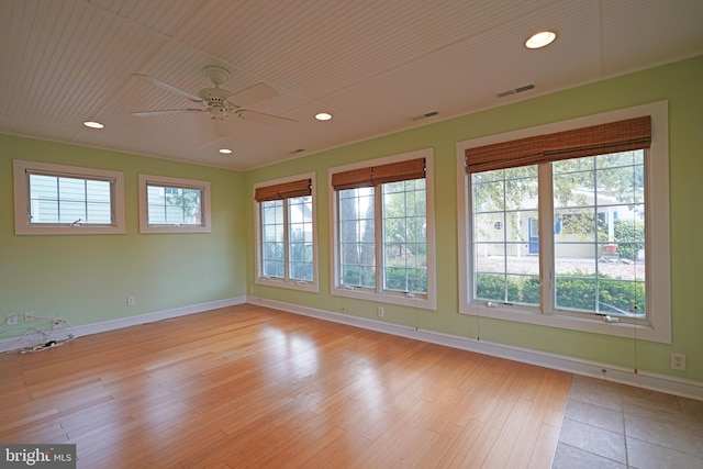 empty room featuring ceiling fan, light hardwood / wood-style flooring, and plenty of natural light