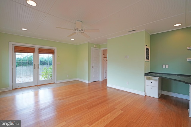 interior space with light wood-type flooring, ceiling fan, built in desk, and french doors