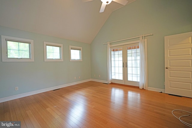 unfurnished room featuring light hardwood / wood-style flooring, ceiling fan, high vaulted ceiling, and french doors