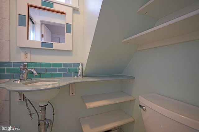 bathroom featuring decorative backsplash and toilet