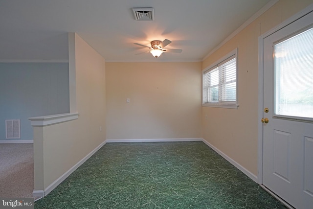 interior space featuring dark carpet, ornamental molding, and ceiling fan