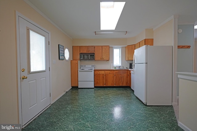 kitchen with white appliances, sink, and crown molding