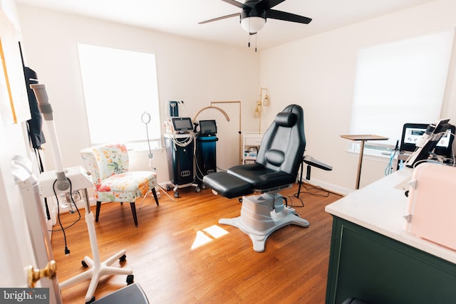 exercise area with ceiling fan and light hardwood / wood-style flooring