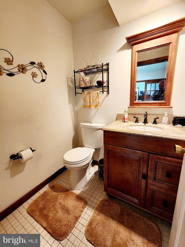 bathroom with tile patterned flooring, vanity, and toilet