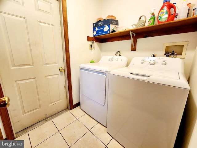 clothes washing area with separate washer and dryer and light tile patterned floors