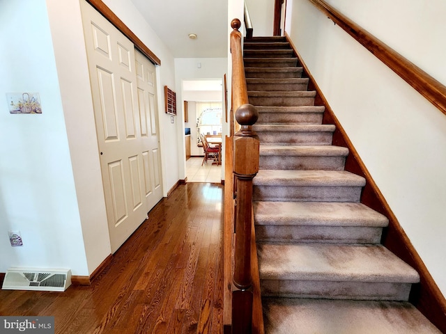 staircase with hardwood / wood-style floors