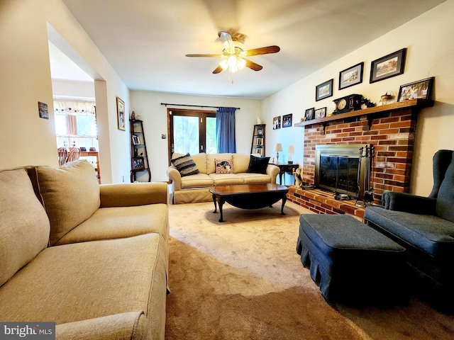 living room featuring carpet floors, a brick fireplace, plenty of natural light, and ceiling fan