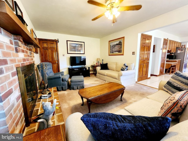 living room featuring ceiling fan, light colored carpet, and a fireplace