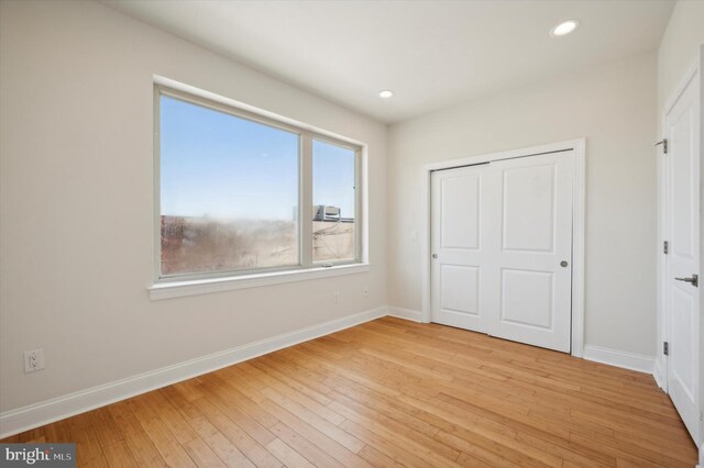 unfurnished bedroom featuring a closet and light hardwood / wood-style flooring