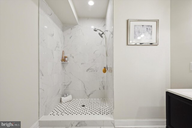 bathroom featuring tiled shower and vanity