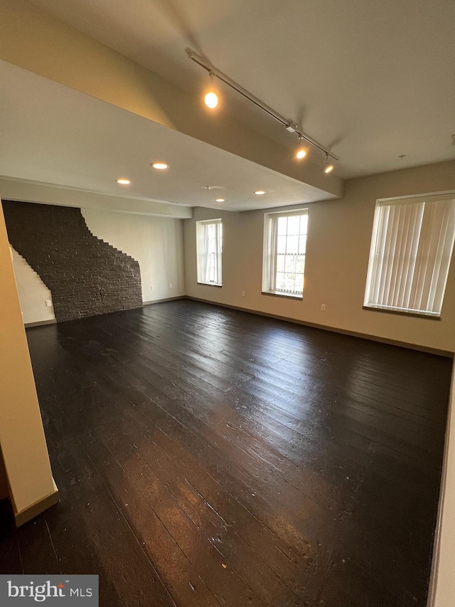 spare room with track lighting and dark hardwood / wood-style floors