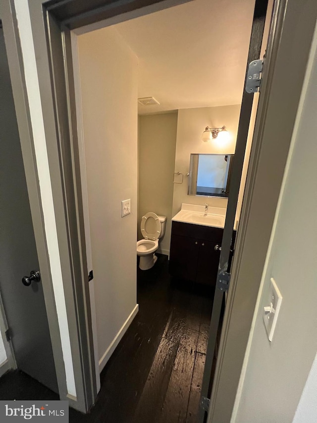 bathroom featuring vanity, toilet, and wood-type flooring