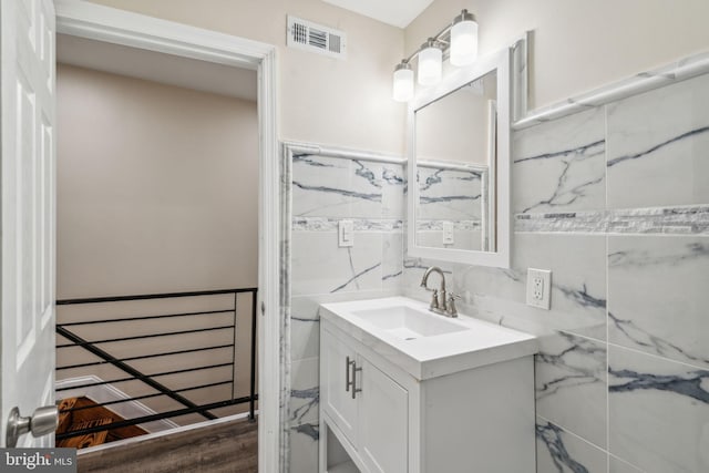 bathroom with vanity, tile walls, and hardwood / wood-style flooring