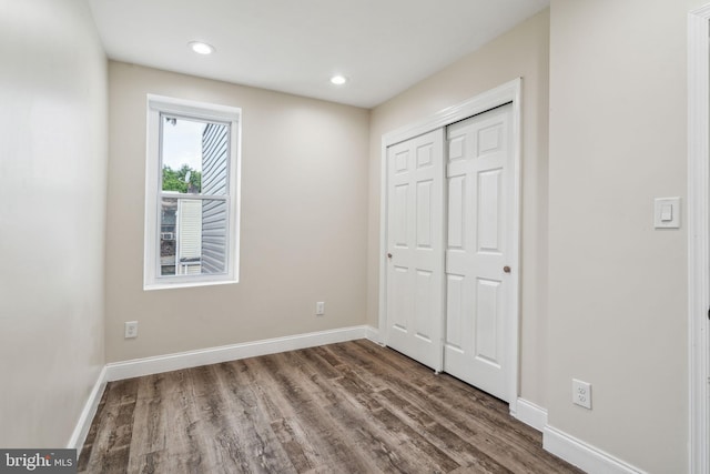 unfurnished bedroom featuring wood-type flooring and a closet