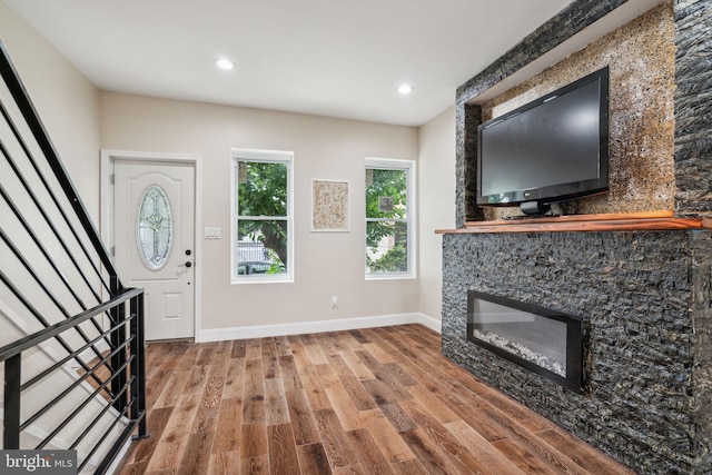 entrance foyer featuring hardwood / wood-style floors and a fireplace