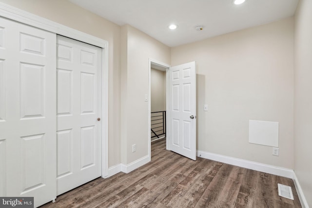 unfurnished bedroom with a closet and wood-type flooring