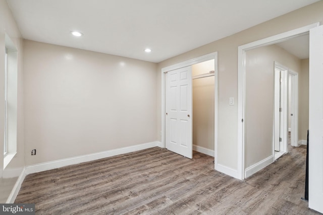 unfurnished bedroom with hardwood / wood-style floors and a closet