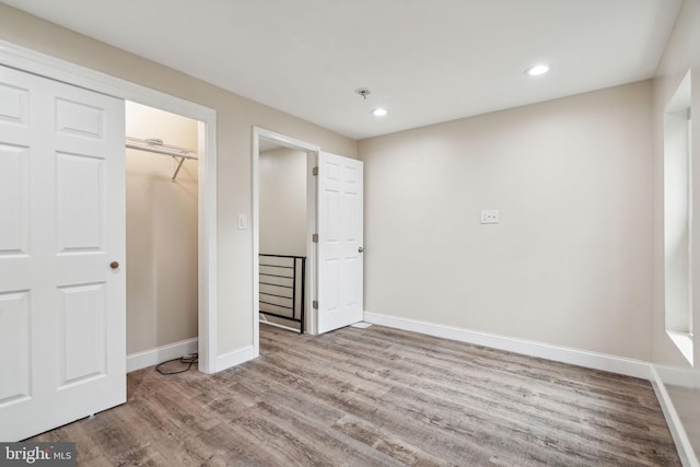 unfurnished bedroom with a closet and wood-type flooring