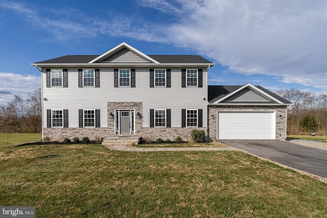 colonial inspired home with driveway, stone siding, an attached garage, and a front yard