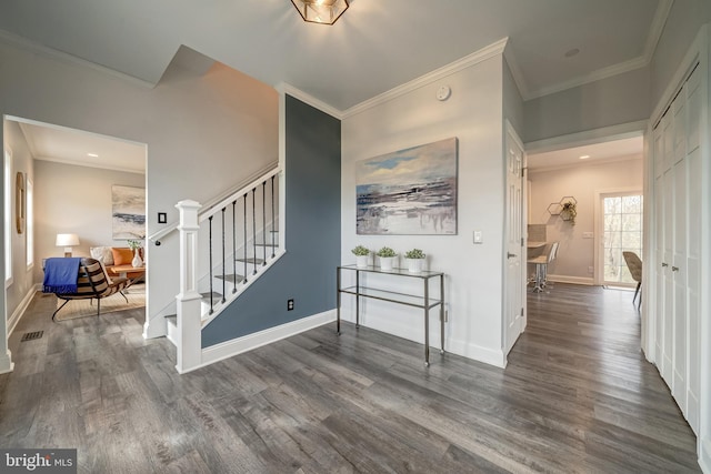 entryway featuring visible vents, stairs, ornamental molding, and wood finished floors