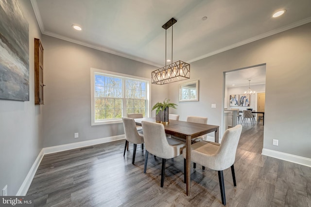 dining space with dark wood-style floors, crown molding, visible vents, and baseboards