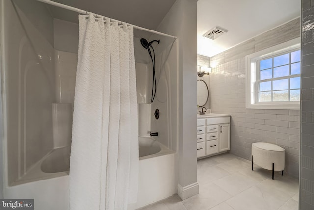 bathroom with visible vents, vanity, tile walls, tile patterned floors, and shower / bathtub combination with curtain