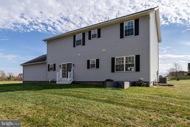 back of house with central air condition unit and a lawn